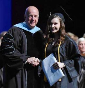 Dr. Michael Helmick congraulates a graduate at commencement exercises