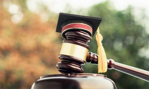 Photo of a gavel with a graduate mortarboard on it representing paralegal careers