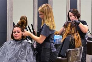 Photo of WPCC students cutting hair at cosmetology stations