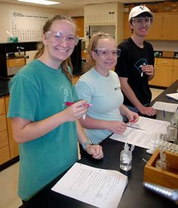 Smiling WPCC students working in the chemistry lab on an assignment