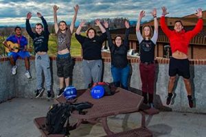 Photo of WPCC students jumping with arms up, excited about being on campus