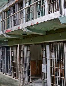 Photo of an empty prison cell block with one door open