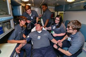 Photo of WPCC Emergency Medical TechniciaN Students posing in the training ambulance