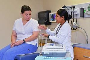 Photo of two WPCC Medical Assisting students working with a heart monitor in the lab