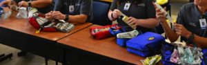 Photo of a table with emergency medical students working with their first aid kits