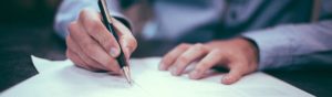 Photo of a man writing on a paper