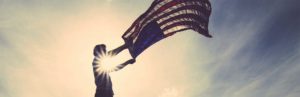 Photo of someone unfurling a flag in the sunlight