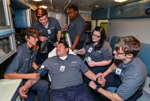 Photo of a group of Emergency Medical Technician students posing inside the back of the WPCC ambulance