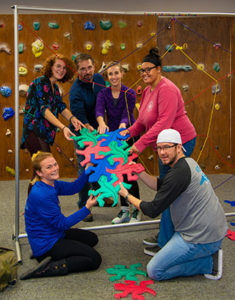 Photo of a group of WPCC recreational therapy students engaging in a class project using large puzzle pieces being passed through a maze