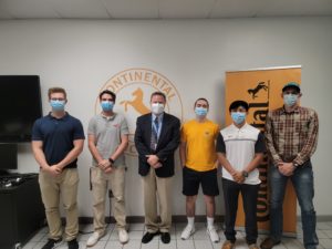 Five students standing in front of Continental's logo with Dean Michael Daniels.