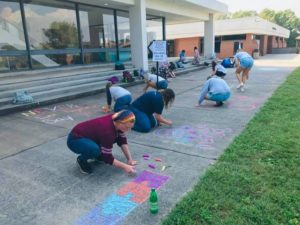 Students Drawing Diversability Messages on the sidewalks in front of Moore Hall