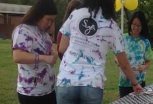 a student models a tie-dye t-shirt