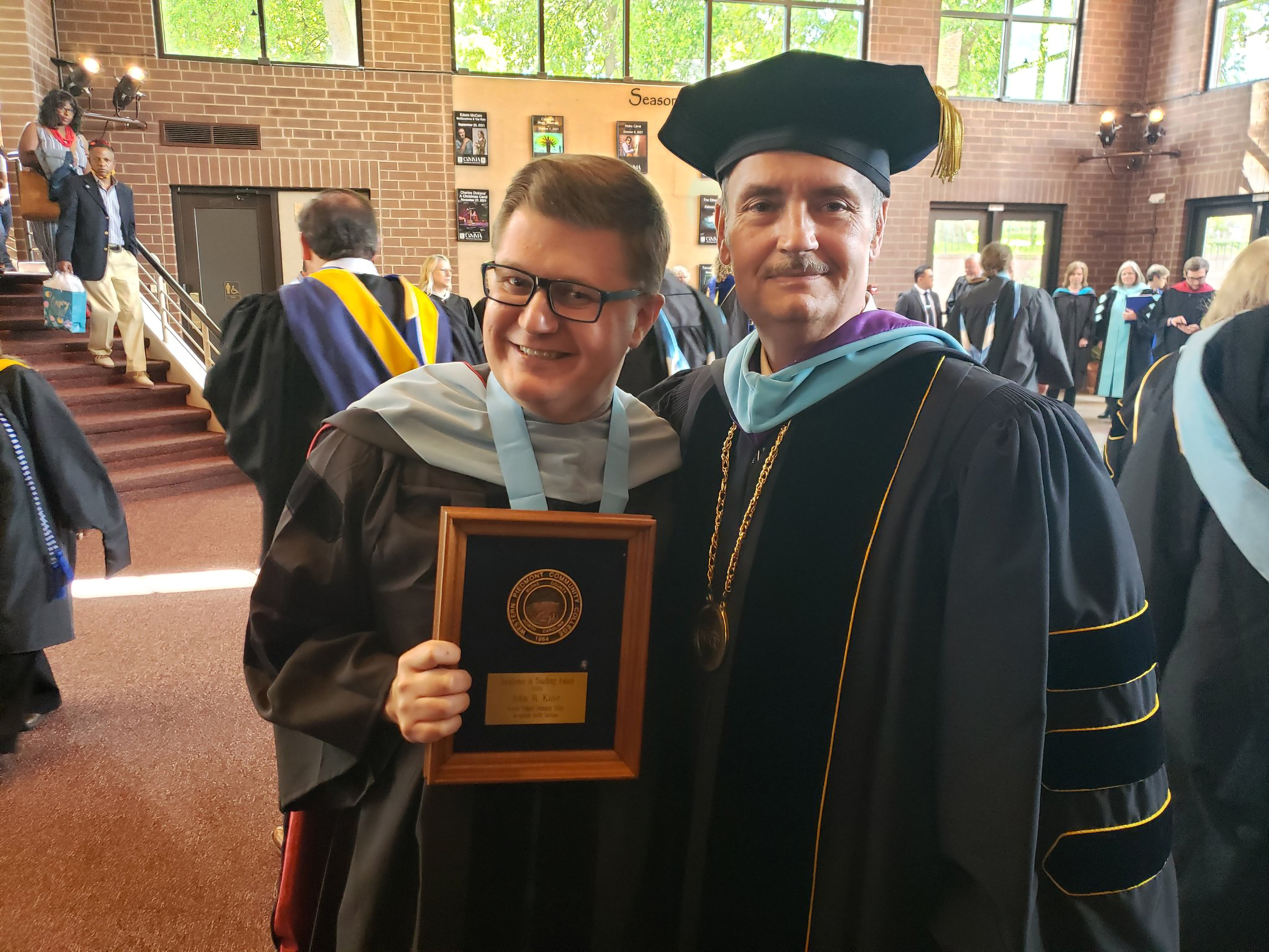 Image of 2 people with 1 holding an award