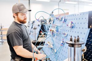 Image of male student looking at wires.