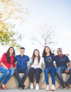 Image of 5 students smiling with arms around each other