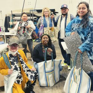 Image of students and professor with their sewing pieces.