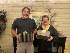 Image of a male and female holding gift boxes.
