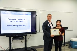 Image of presdient dr. welch with the academic excellence award recipient melinda sajche chay.