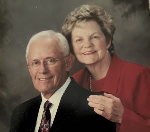 Image of Roy and Jan Walters smiling in front of a dark grey background.