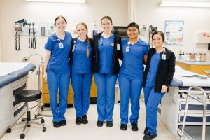 5 medical assisting students smiling for a photo