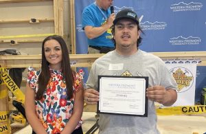 Image of student holding scholarship award with foundation executive director